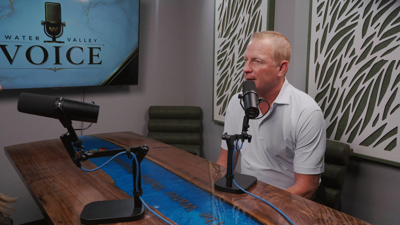 Ryan Bach talking into a microphone in the Water Valley Voice podcast studio.